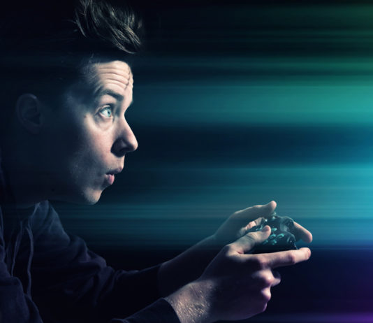 Mann mit Controller vor Bildschirm