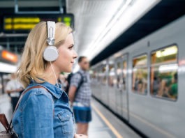 Frau mit Kopfhörern am Zug; © Halfpoint - stock.adobe.com