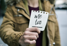 Frau hält Zettel mit Aufschrift "me too"