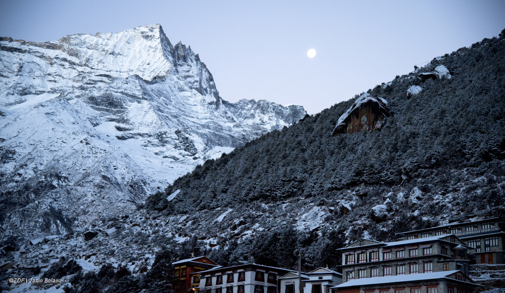 "Everest": Man sieht ein Dorf, das am Fuß eines schneebedeckten Berges liegt