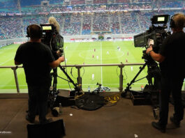 Zwei Kameras filmen ein Fußballspiel in einem großen Fußballstadion