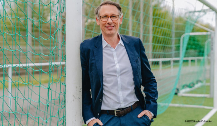 Sportschau-Chef Steffen Simon lehnt an Pfosten