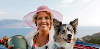 Michaela May mit Hund, Hut und einer Urne im Cabrio
