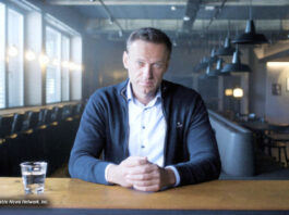 Alexei Nawalny sitzt an einem Bartresen und blickt in die Kamera.