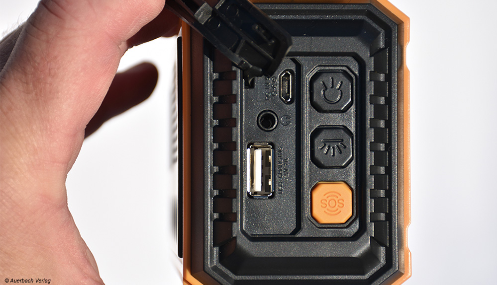 Hinter einer Schutzklappe verbergen sich ein Micro-USB-Eingang zum Laden des Akkus, eine USB-Buchse zum Laden eines Smartphones und ein Kopfhöreranschluss