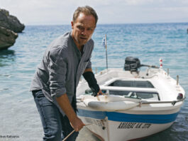 Mann zieht Boot an Land