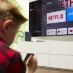 Kind vor Fernseher mit Netflix Logo