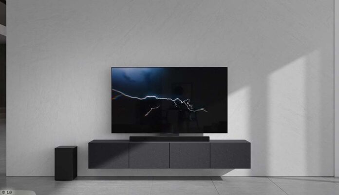 LG Soundbar mit Subwoofer vor Fernseher, auf dessen Display ein Blitz zu sehen ist. Vorschau auf die LG Neuheiten bei der CES 2023