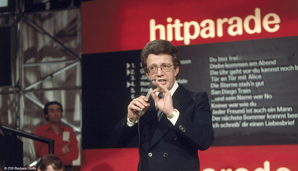 "Die ZDF-Kultnacht - Das Beste aus der "Hitparade"": Dieter Thomas Heck steht im Studio der "Hitparade" und spricht ins Mikrofon.