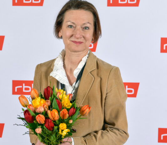 Martina Zöllner mit Blumenstrauß vor RBB-Wand