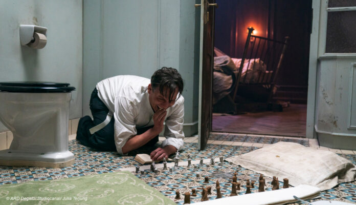 Oliver Masucci vor Schachbrett in Badezimmer
