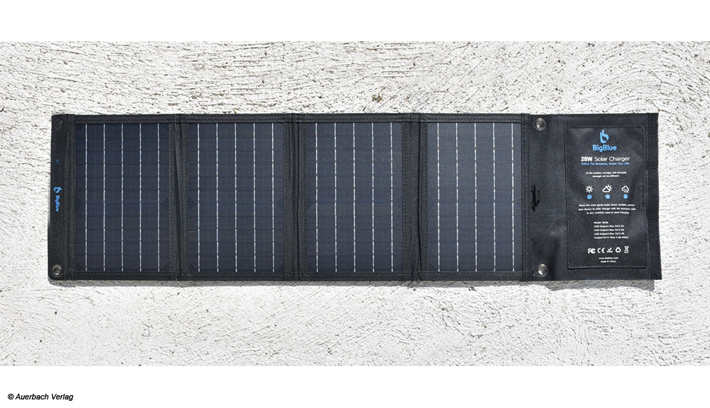 Vollständig aufgefaltet ist der Solarlader BigBlue 28 W 102 × 28 cm groß und wenige Millimeter dick. Zum Aufhängen sind Ösen vorgesehen