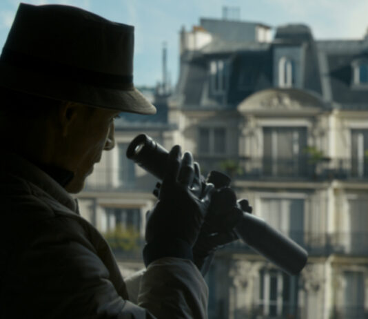 Michael Fassbender mit Fernrohr am Fenster