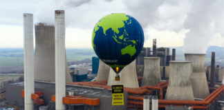 Ein Heißluftballon von Greenpeace vor einem Kohlekraftwerk