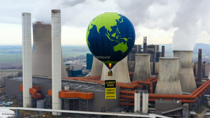 Ein Heißluftballon von Greenpeace vor einem Kohlekraftwerk