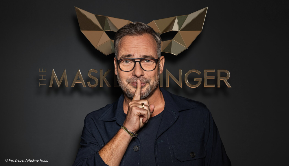 Matthias Opdenhövel vor The Masked Singer Logo