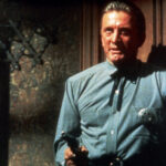 Sheriff Matt Morgan (Kirk Douglas) steht in einer Tür und hält eine Pistole in der Hand.
