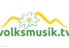 Neues Logo von Volksmusik.tv mit einer Blüte und angedeuteten Bergen über dem Schriftzug.