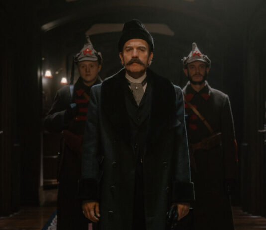 Szene aus "Ein Gentleman in Moskau": Der Graf steht im Hotel, dahinter zwei Soldaten. (Paramount+)