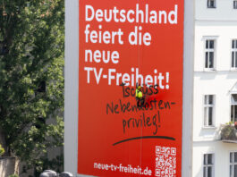 "Deutschland feiert die neue TV-Freiheit" Plakat an Häuserfassade