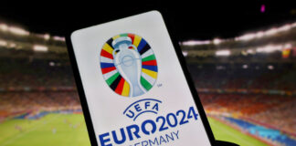 Smartphone mit EURO 2024 Logo im Fußballstadion