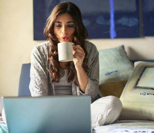 Frau im Bett mit Laptop