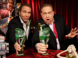 Peter Rütten und Oliver Kalkofe in SchleFaZ: mit grünen Drinks, ein kleiner Roboter und ein Skelett liegen auf dem Tisch vor ihnen.