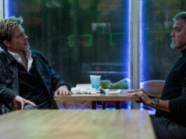 George Clooney und Brad Pitt sitzen am Tisch