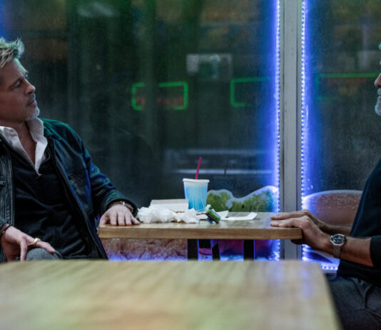 George Clooney und Brad Pitt sitzen am Tisch