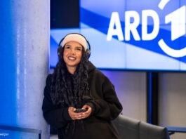 Frau mit Kopfhörern unter dem ARD Logo