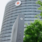 Vodafone Gebäude mit Router im Vordergrund