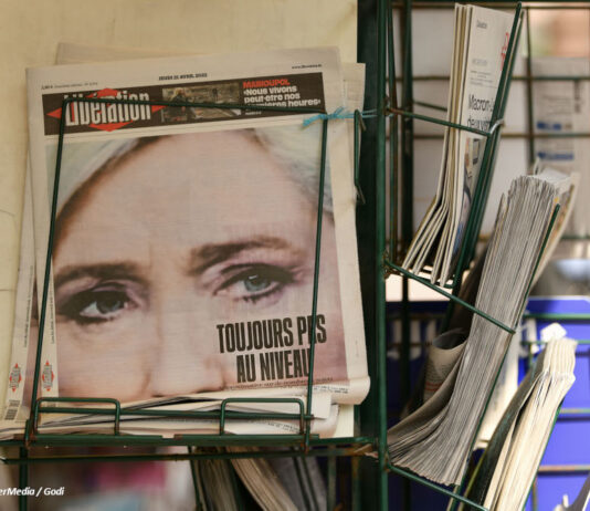 Bild einer französischsprachigen Zeitung im Ständer, auf der ersten Seite ein Foto von Marine Le Pen