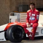 Ayrton Senna (Gabriel Leone) sitzt auf seinem F1-Rennauto.