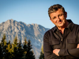 Schauspieler Hans Sigl steht vor einem Bergpanorama