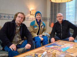 Bjarne Mädel, Katharina Marie Schubert und Olli Dittrich sitzen in ihren Kostümen auf einer Couch bei Dreharbeiten