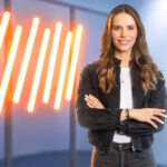 Moderatorin Lili Engels steht mit verschränkten Armen vor einigen Lampen.
