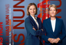 Bettina Schausten und Anne Gellinek schauen in die Kamera, im Hintergrund und daneben steht der Schriftzug "WAS NUN".
