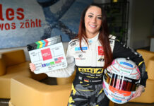 Carrie Schreiner mit Rennfahrerhelm und Filmklappe