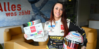 Carrie Schreiner mit Rennfahrerhelm und Filmklappe