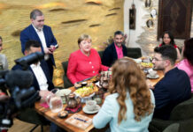 Angela Merkel mit Geflüchteten im Restaurant
