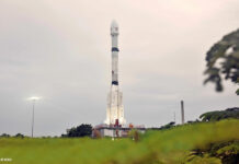 Eine weiße Rakete steht auf ihrer Startposition, im Hintergrund ein diesiger Himmel.