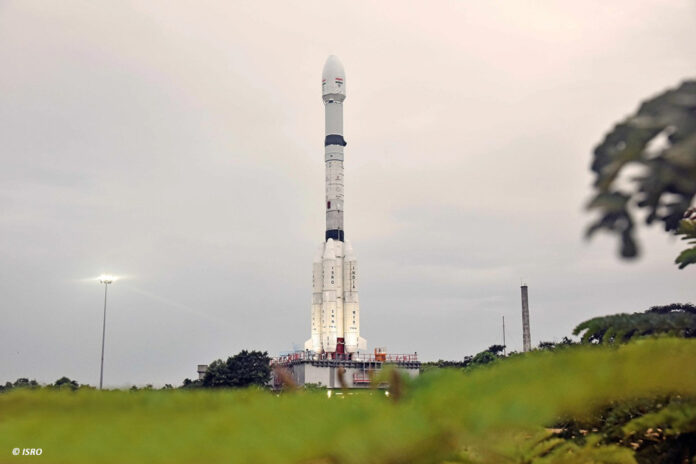 Eine weiße Rakete steht auf ihrer Startposition, im Hintergrund ein diesiger Himmel.
