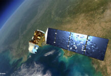 Ein Renderbild des Satelliten Landsat 8 vor der Erde.