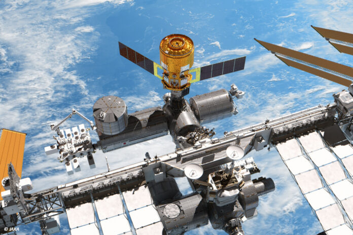 Ein Renderbild zeigt die Internationalen Raumstation mit einem angedockten "HTV-X"- Raumfrachter von "oben". Im Hintergrund sieht man das Blau der Erde und ein paar Wolken.