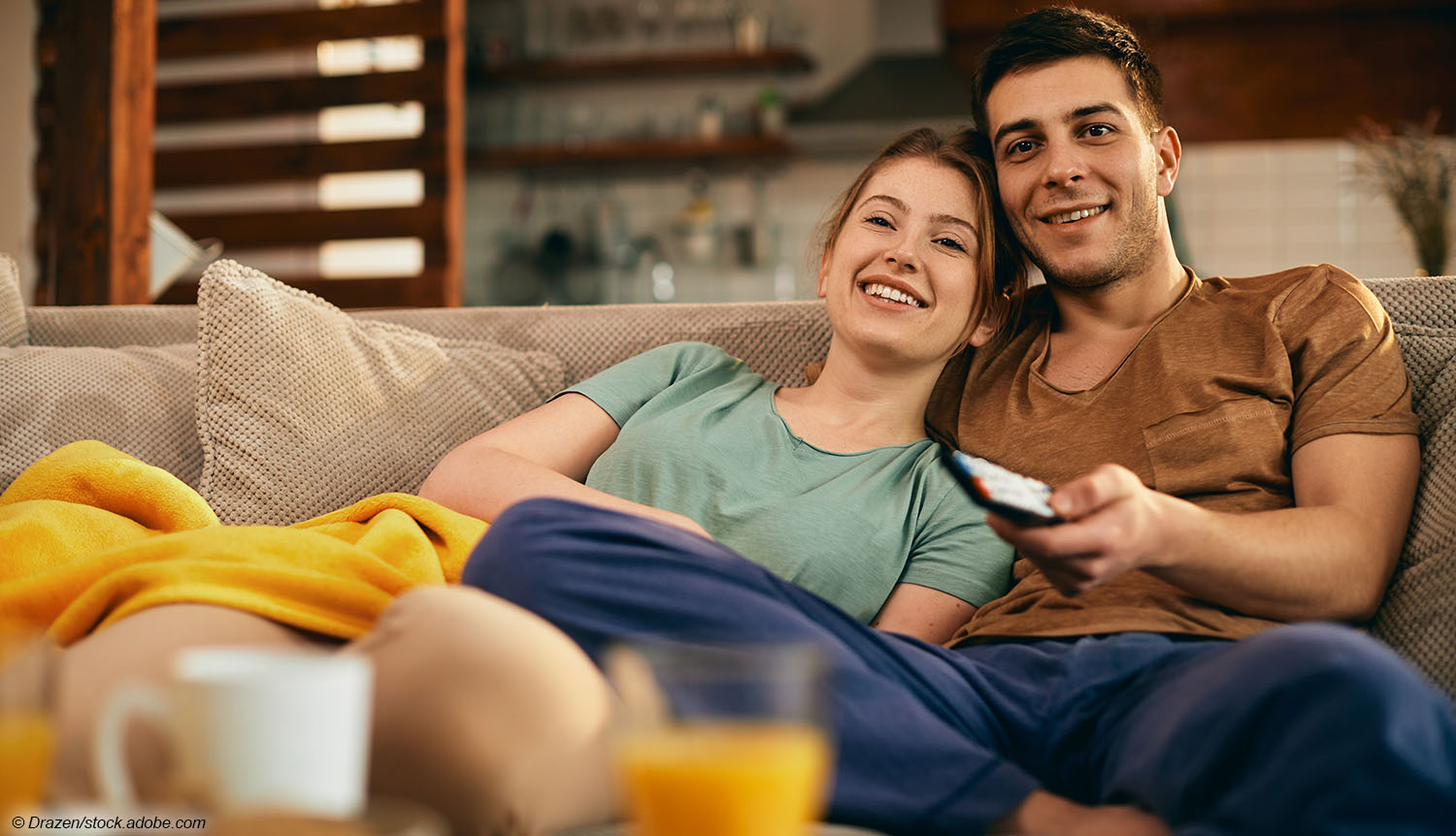Frau Mann auf Couch mit Fernbedienung